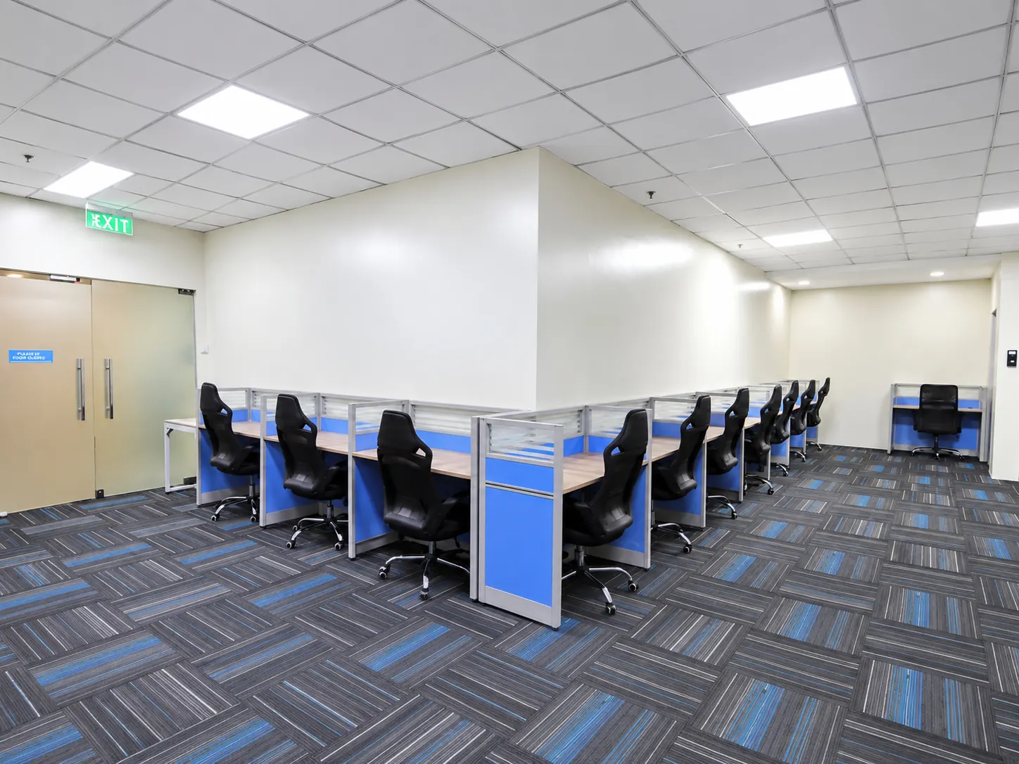 An open operations floor with rows of workstations, blue partitions, and computer stations.