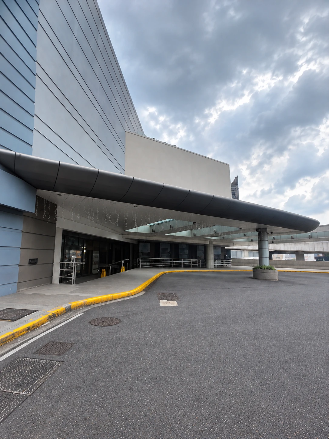 Street-level view of a modern commercial building exterior with a covered entrance.