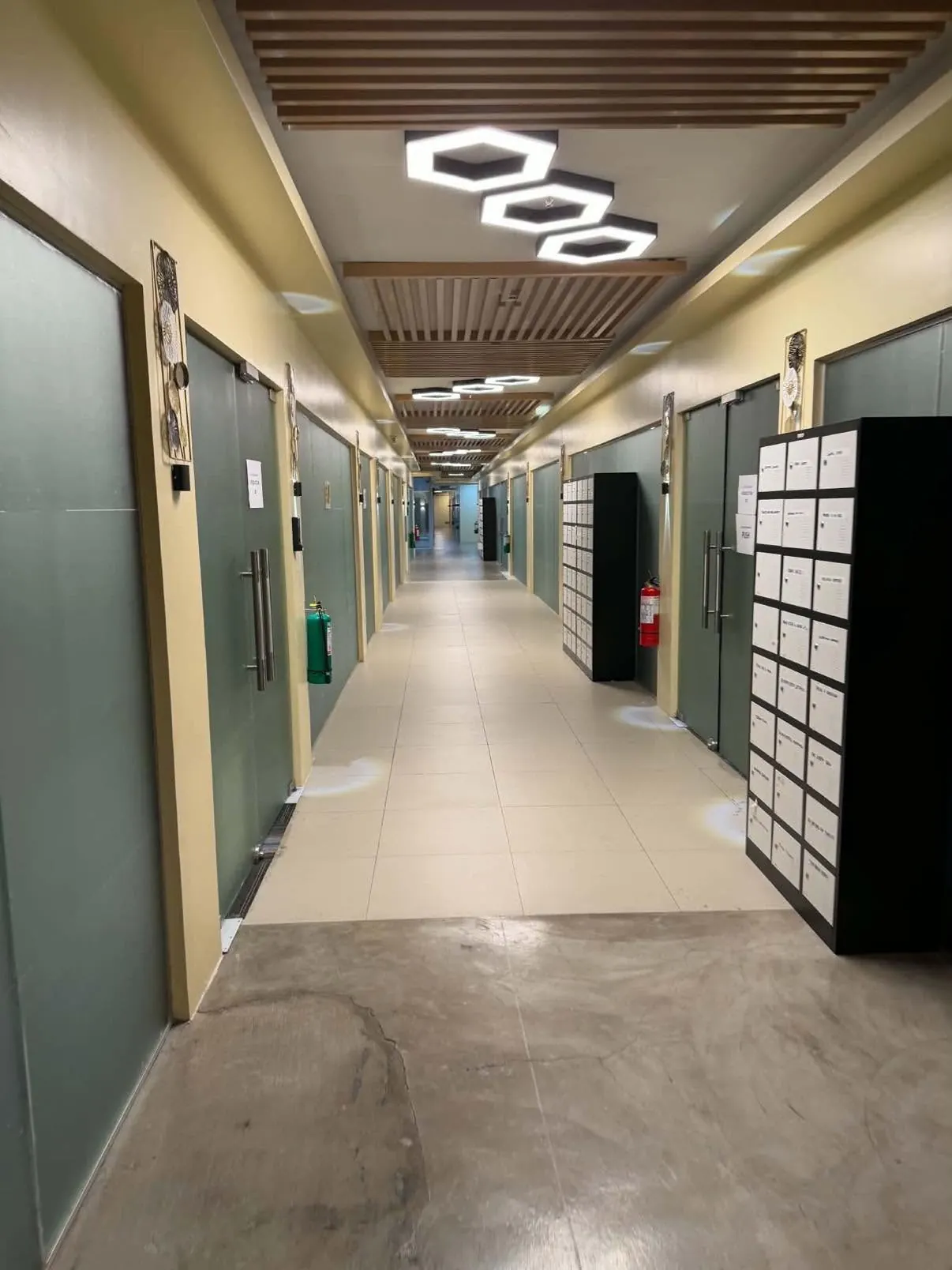 Client supplied view of an office corridor with multiple doors and lockers.